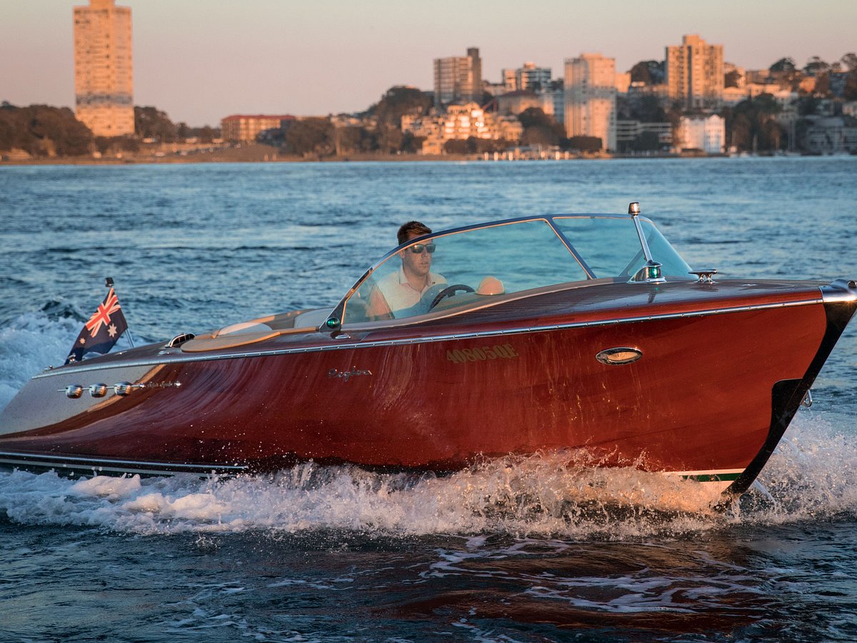 Classic wooden luxury speedboat Mon Cheri cruising at sunset on Brisbane River